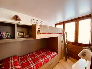 een slaapkamer met een stapelbed en een rode deken bij Charlotte Lodge Cervinia in Breuil-Cervinia