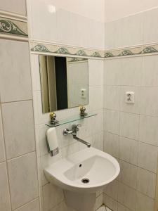 Baño blanco con lavabo y espejo en Hotel Slovan, en Žilina