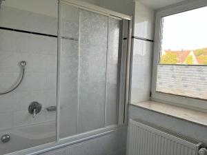 a shower with a glass door in a bathroom at Wiehengebirgs Fernblick App 2 in Bad Essen +17 photos
