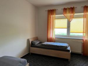 een slaapkamer met een bed voor een raam bij Wiehengebirgs Fernblick App 2 in Bad Essen