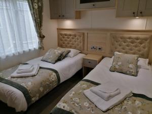 two beds in a bedroom with towels on them at Alberta Holiday Park in Seasalter