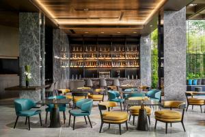 un restaurante con mesas y sillas y un bar en The G Shenzhen, A Tribute Portfolio Hotel en Shenzhen