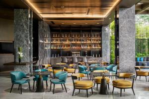 a restaurant with tables and chairs and a bar at The G Shenzhen, A Tribute Portfolio Hotel in Shenzhen