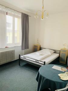 een slaapkamer met een bed, een tafel en een raam bij Hotel Slovan in Žilina