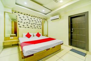 a bedroom with a bed with red pillows and a mirror at OYO Hotel My Lord in Bhopal