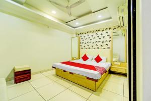 1 dormitorio con 1 cama con almohadas rojas en OYO SPOT ON Hotel My Lord en Bhopal