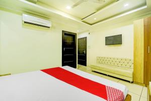 a bedroom with a white bed and a couch at OYO SPOT ON Hotel My Lord in Bhopal