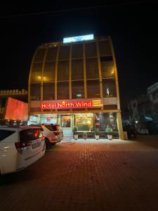 zdrowy budynek wiatru północnego z samochodami zaparkowanymi przed budynkiem w obiekcie Hotel Northwind Mohali w mieście Mohali