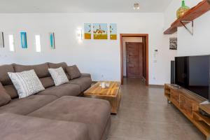 a living room with a couch and a flat screen tv at Villa near San Antonio sleeps 10 in Ses Paisses