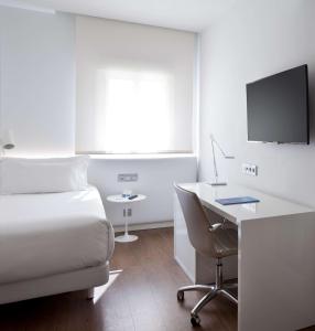 Habitación de hotel con cama y escritorio con ordenador en NH Madrid Atocha, en Madrid