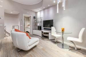 a living room with white furniture and a tv at [DUOMO 14 min] Orange Milano M3 in Milan