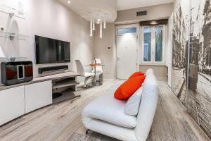un salon avec un canapé blanc et une télévision dans l'établissement [DUOMO 14 min] Orange Milano M3, à Milan