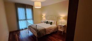 a bedroom with a bed and a large window at 24A01 Apartamento Cabrales in Arenas de Cabrales
