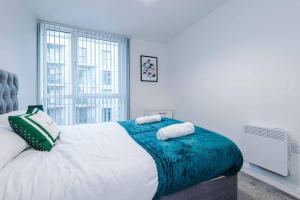 a bedroom with a large bed with two towels on it at Luxury balcony apartment near Manchester City Centre - Free Secure Parking - Self-Check In in Manchester