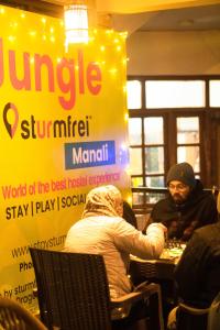 a group of people sitting at a table in a restaurant at Jungle by sturmfrei Manali in Manāli