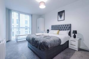 a bedroom with a large bed and a large window at Luxury balcony apartment near Manchester City Centre - Free Secure Parking - Self-Check In in Manchester