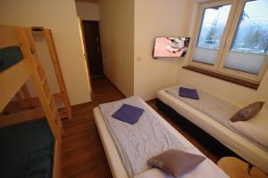 a room with three bunk beds and a window at Ski House Szczyrk - Czyrna in Szczyrk
