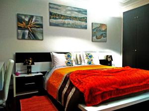 um quarto com uma cama com um cobertor vermelho em GuestHouse Pombinha em Nazaré