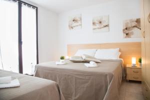 ein weißes Schlafzimmer mit 2 Betten und Handtüchern darauf in der Unterkunft Villetta Concetta in Marina di Pescoluse