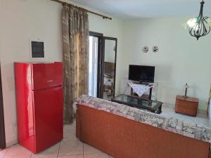 ein Wohnzimmer mit einem roten Kühlschrank und einem TV in der Unterkunft SIGRI'S BEAUTY in Sígrion