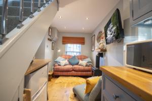 a living room with a couch and a television at Kitten Cottage in West Witton