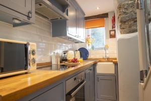 a kitchen with a counter top with a microwave at Kitten Cottage in West Witton