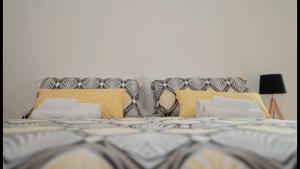 een slaapkamer met een bed met kussens erop bij P&D APARTMENTS NAVIGLI VIA CASALE in Milaan
