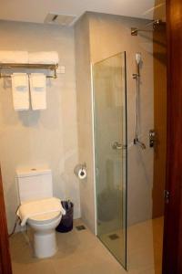 長灘島的住宿－Paradise Garden Hotel and Convention Boracay Powered by ASTON，浴室设有卫生间和带毛巾的淋浴。