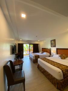 長灘島的住宿－Paradise Garden Hotel and Convention Boracay Powered by ASTON，酒店客房配有两张床和一张书桌