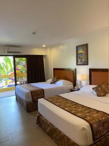 長灘島的住宿－Paradise Garden Hotel and Convention Boracay Powered by ASTON，酒店客房设有两张床和一个阳台。