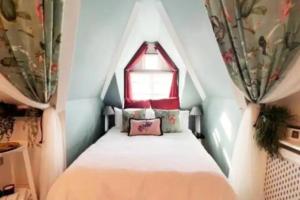 a small bedroom with a bed with a window at The Maple Retreat - Hampstead in London