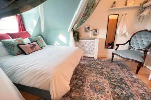 a bedroom with a bed and a chair and a rug at The Maple Retreat - Hampstead in London
