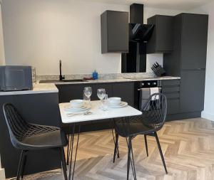 cocina con mesa blanca y 2 sillas en Stylish Apartments near the sea front at Morecambe, en Heysham