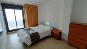 1 dormitorio con cama y ventana grande en A H Rentals Garbi Apartamento con parking, en Peñíscola
