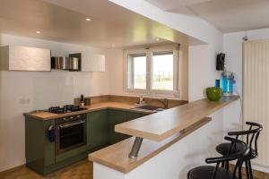 a kitchen with green cabinets and a wooden counter top at le Guydine in Puiseux