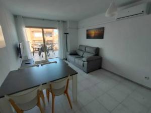 a living room with a couch and a table and chairs at A H Rentals Carles III Apartamento 150mtrs playa in Sant Carles de la Ràpita