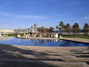 A H Rentals Carles III Apartamento 150mtrs playa في سانت كارليس دي لا رابيتا: مسبح في حديقة فيها نخل