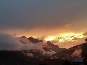 una vista de una puesta de sol con nubes en las montañas en B&B IL BUCANEVE, en Santo Stefano di Cadore