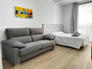 sala de estar con sofá y cama en A H Rentals Picasso apartamento, en Vinarós
