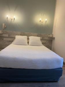 a bedroom with a large bed with two pillows at Logis Hôtel Le Clement V in Roquemaure