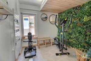 siłownia z rowerami treningowymi i zieloną ścianą w obiekcie La maison de perros w mieście Perros-Guirec
