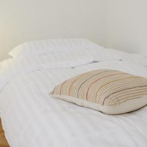 - un lit blanc avec un oreiller dans l'établissement Lama Hostel, à Ivano-Frankivsk