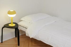 - une chambre avec un lit et une table avec une lampe dans l'établissement Lama Hostel, à Ivano-Frankivsk