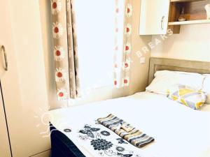 um pequeno quarto com uma cama e uma janela em Marlow - Gold 2 bed with veranda and parking at Seal Bay Resort em Selsey