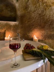a glass of wine and a plate of grapes and candles at Chakra Special Caves in Urgup