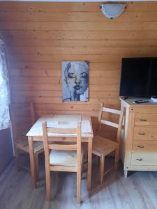 ein Holzzimmer mit einem Tisch, Stühlen und einem Schreibtisch in der Unterkunft Willa Podgórska in Korbielów