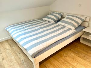 uma cama com almofadas listradas azuis e brancas em Stadtherz Lingen em Lingen
