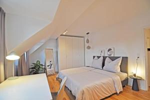 ein weißes Schlafzimmer mit einem Bett und einer Treppe in der Unterkunft Design-Highlight: Stilvolles Altstadt-Apartment! in Wittlich