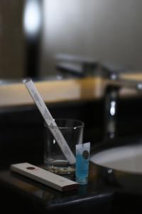 a pair of toothbrushes in a glass on a counter at ايتن للشقق المخدومه in Taif