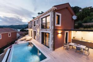 a house with a swimming pool and a patio at Villa Val & Sol in Dubrovnik